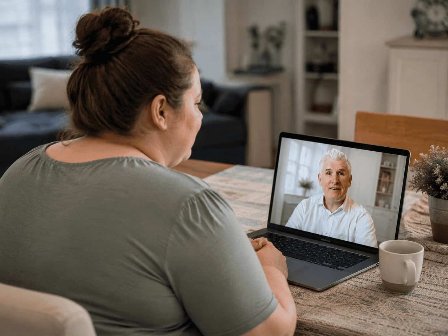 A patient at home on a video consultation, her doctor on the laptop screen