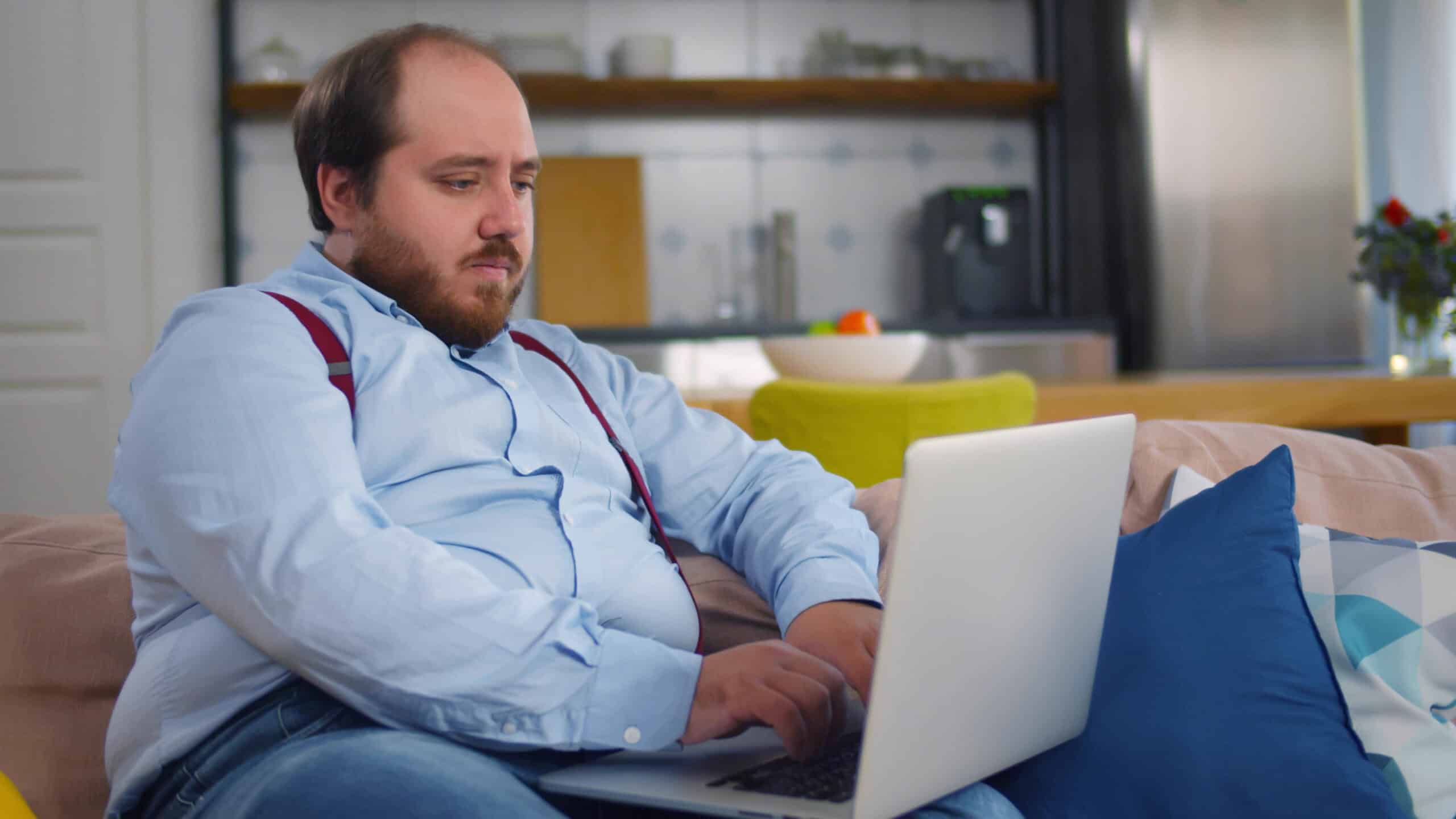 A man on his sofa at home with a laptop