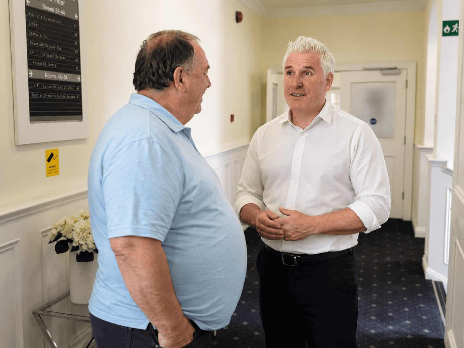 A patient arriving at the clinic and being greeted by his consultant
